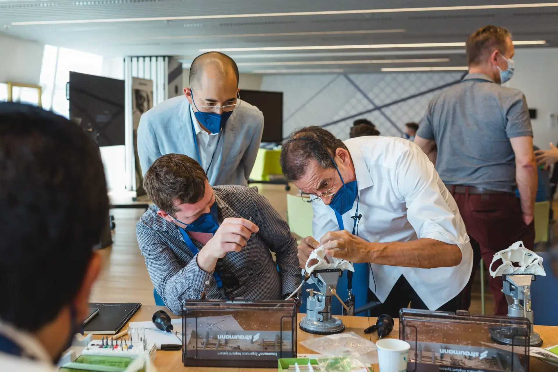 Dr. Aparicio with two participant during the hands-on with a 3D dental model.